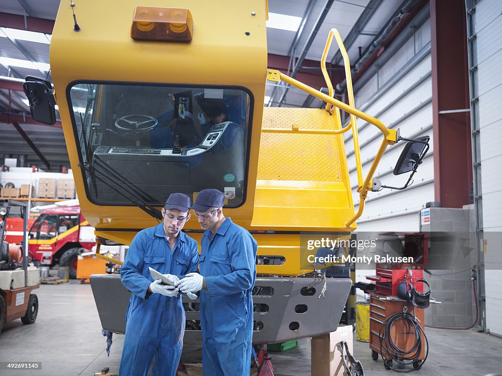 Engineers use digital tablet in truck repair factory
