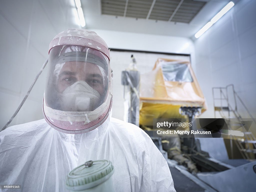 Portrait of paint spray technician in truck repair factory, close up