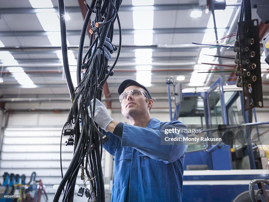 Engineer installing new electrics in truck repair factory