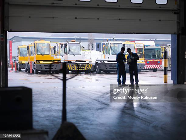 engineers silhouetted in doorway in truck repair factory - monty shadow - fotografias e filmes do acervo