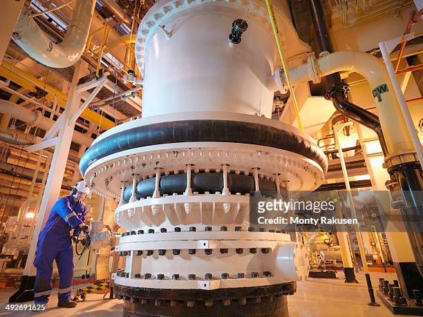 engineer adjusting seawater valve in power - energia nucleare foto e immagini stock