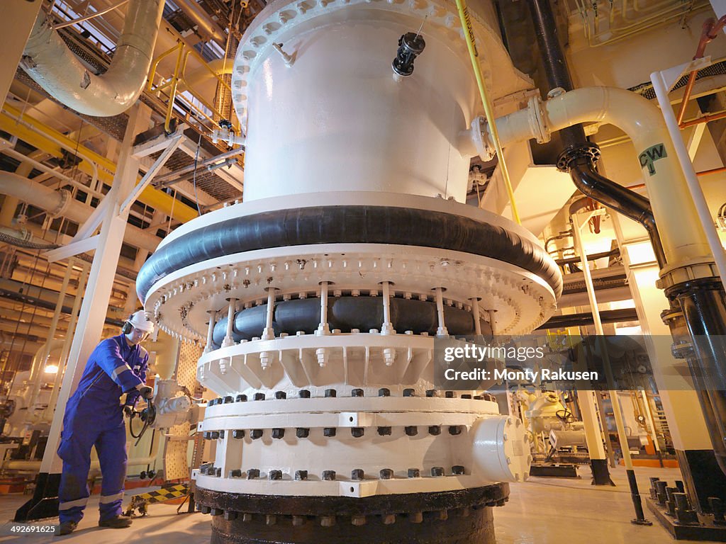 Engineer adjusting seawater valve in power