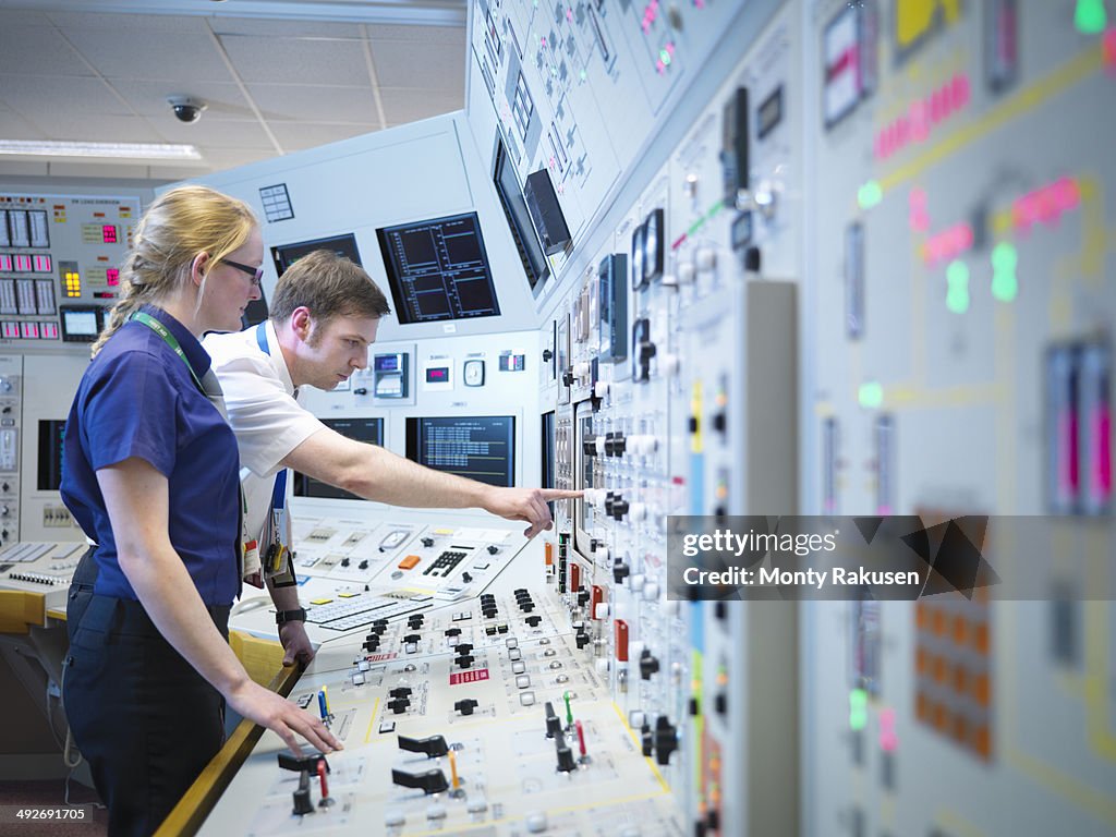Female operator and trainee in nuclear power station control room simulator