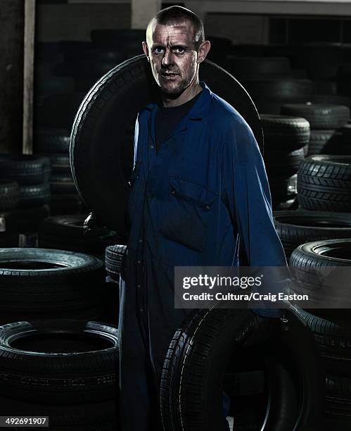 car mechanic in workshop with car tires - overalls stock pictures, royalty-free photos & images