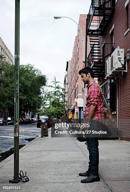 young man looking at broken bike on street - rob cross stock pictures, royalty-free photos & images