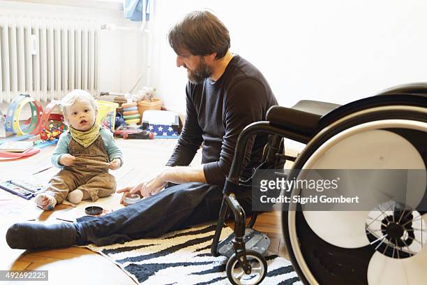 Disabled father with son playing on floor
