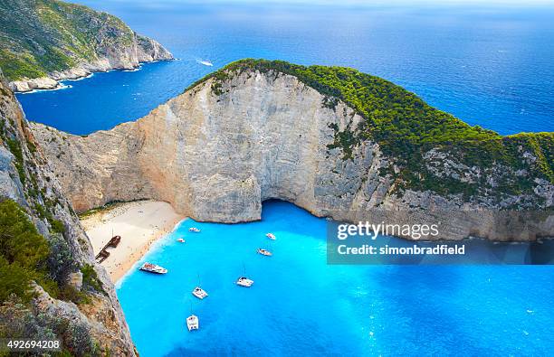 boats at shipwreck beach, zakynthos - greece stock pictures, royalty-free photos & images