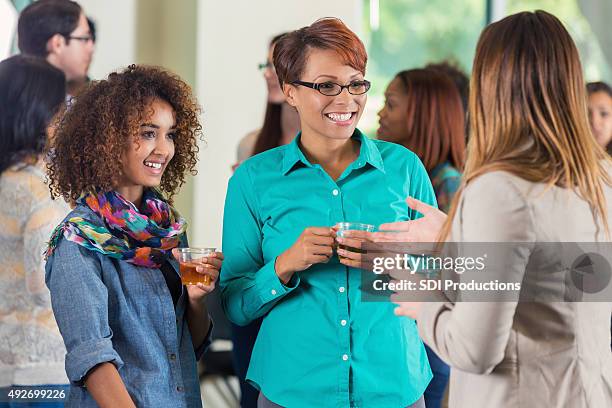 mother and daughter at college meet and greet party - presentation party stockfoto's en -beelden