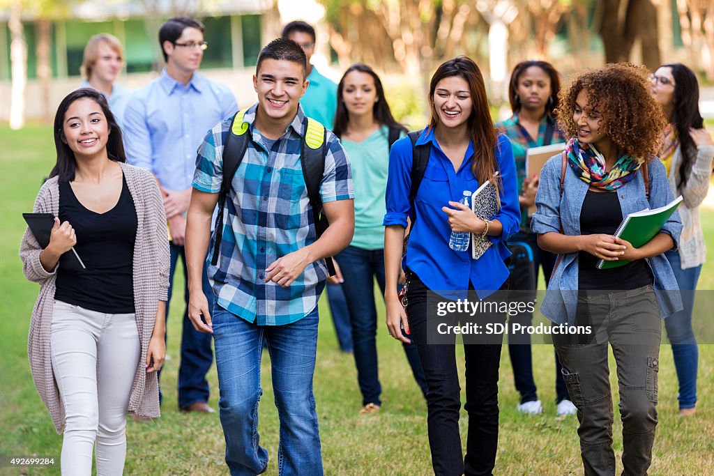 Diverse group of college students walking on beautiful campus