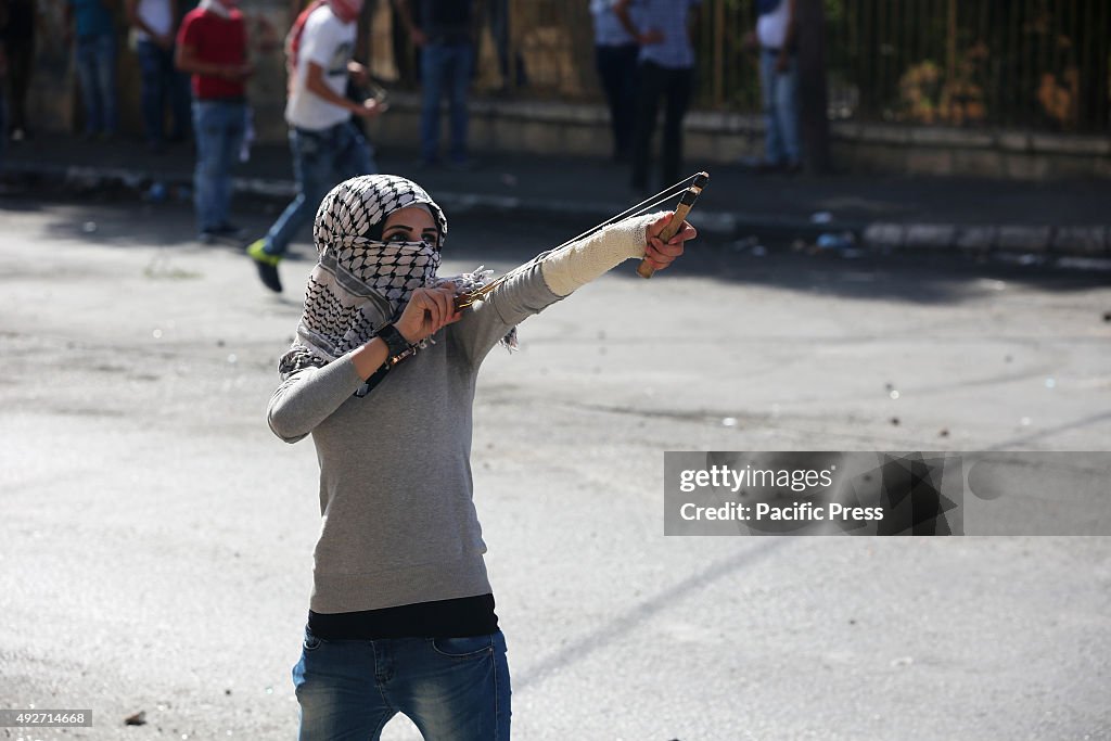 A female Palestinian demonstrator is seen using a slingshot...