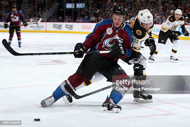 Jack Skille of the Colorado Avalanche tries to control the puck against Tommy Cross of the Boston Bruins at Pepsi Center on October 14, 2015 in...
