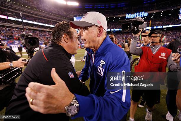 Head Coach Jim Tomsula of the San Francisco 49ers and Head Coach Tom Coughlin of the New York Giants shake hands on the field following the game at...