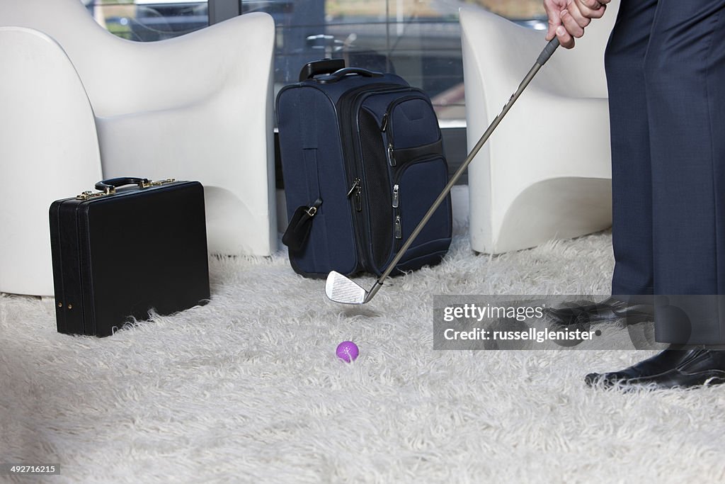 Close-up of businessman playing golf in office