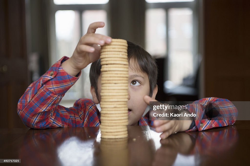 Boy stacking up biscuits