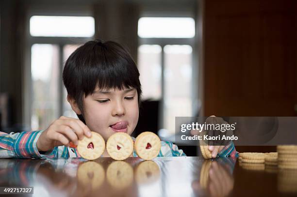 boy playing with biscuits - candy on tongue stock pictures, royalty-free photos & images