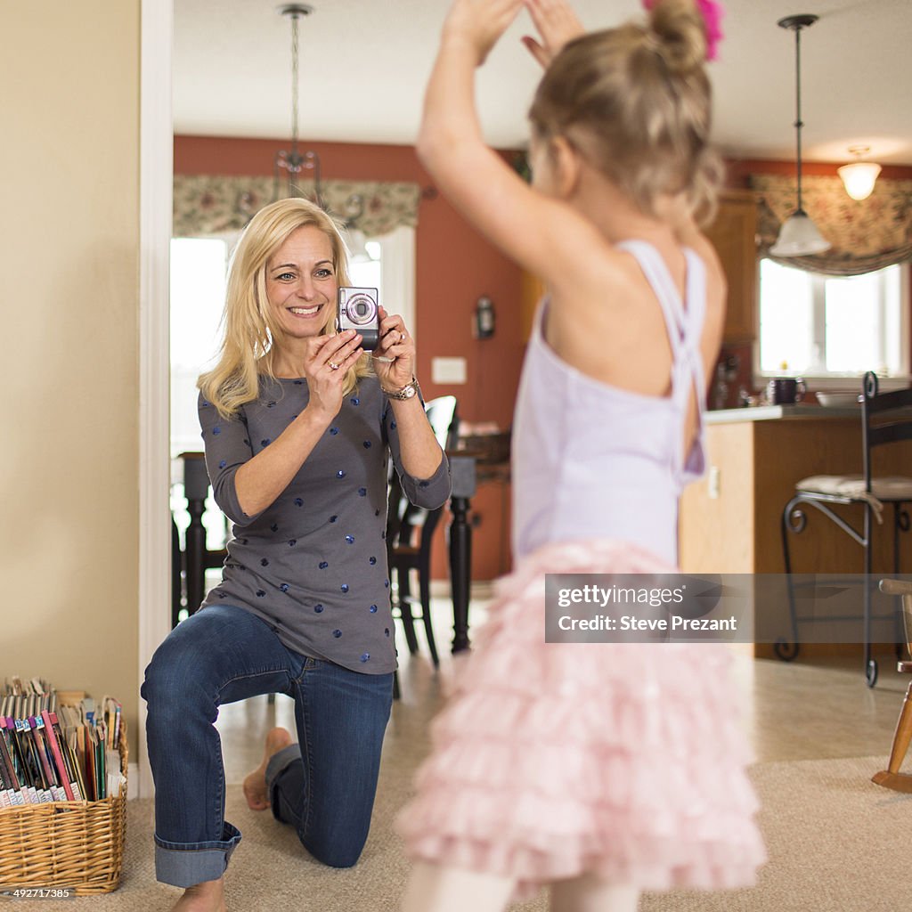 Mother photographing daughter in ballet pose