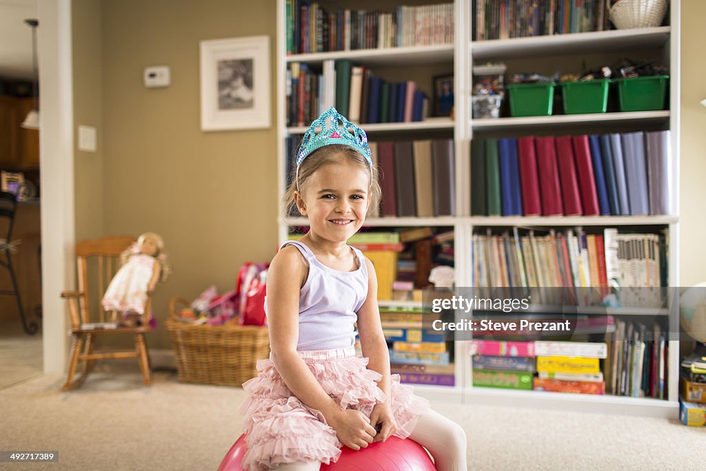 Portrait of cute young girl sitting on exercise ball