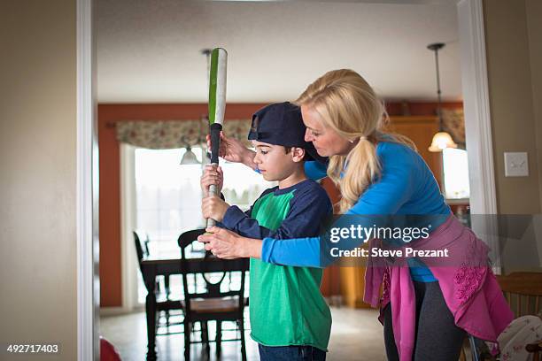 mother teaching son to hold a baseball bat - baseball mom fotografías e imágenes de stock