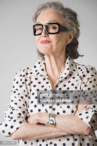 portrait of senior woman, arms crossed - grey hair cool woman stock-fotos und bilder