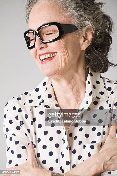 portrait of senior woman, arms crossed, laughing - coole oma stock-fotos und bilder