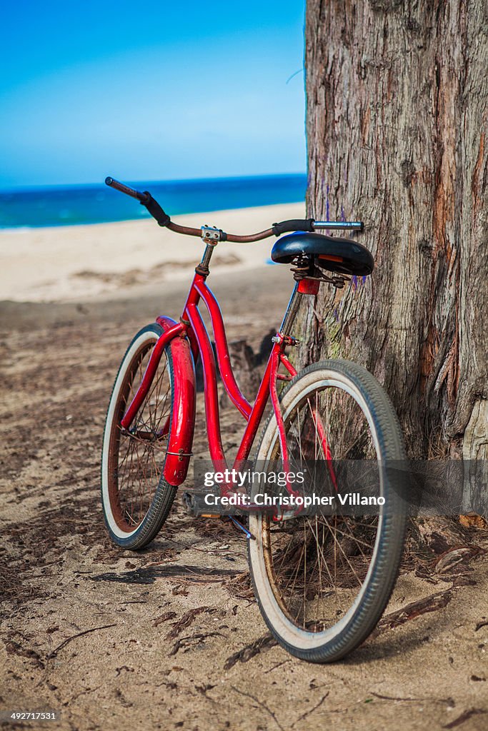 Red bicycle parked on beach, Kaua'i, Hawaii, USA