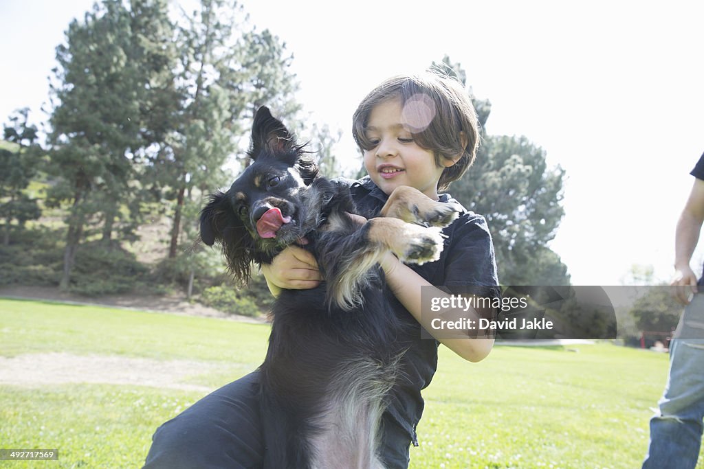 Young boy in park playing with his dog