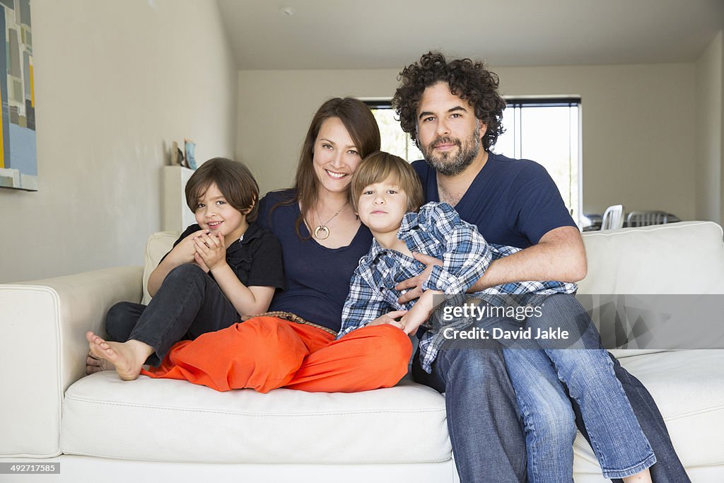 Portrait of family with two boys on sofa