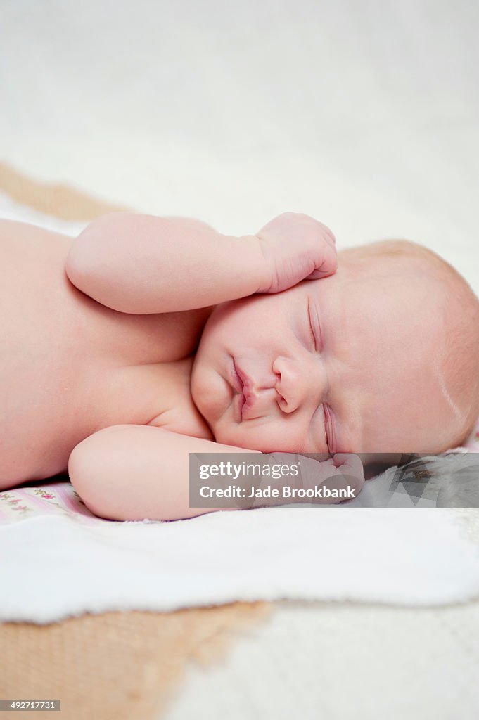Baby asleep with hands beside face