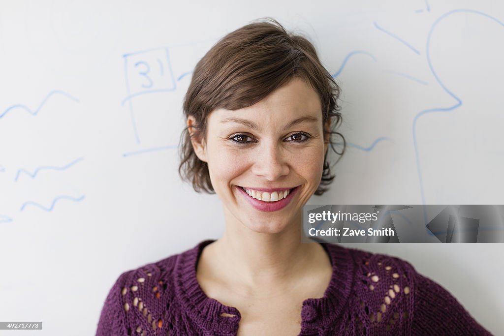 Close up portrait of young woman in front of whiteboard