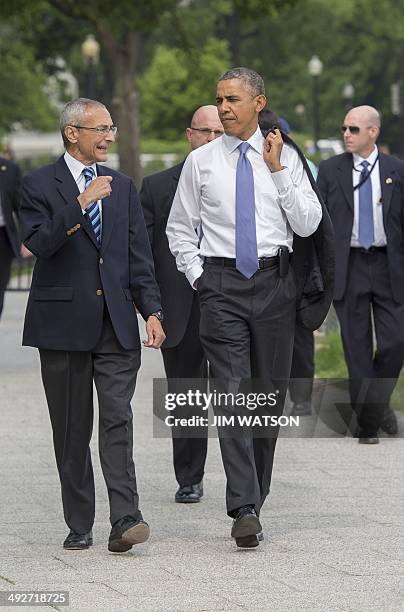 President Barack Obama walks with White House Councilor John Podesta through the Ellipse in Washington, DC, May 21 on their way to the US Department...