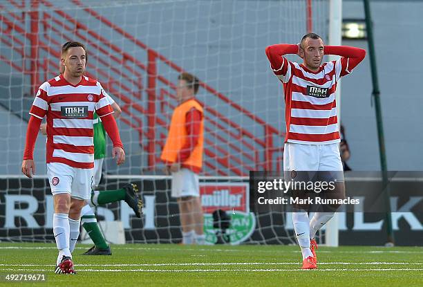 Darian MacKinnon and Jon Routledge of Hamilton Academical walk back to the half way line to restart the game after Jason Cummings of Hibernian socred...