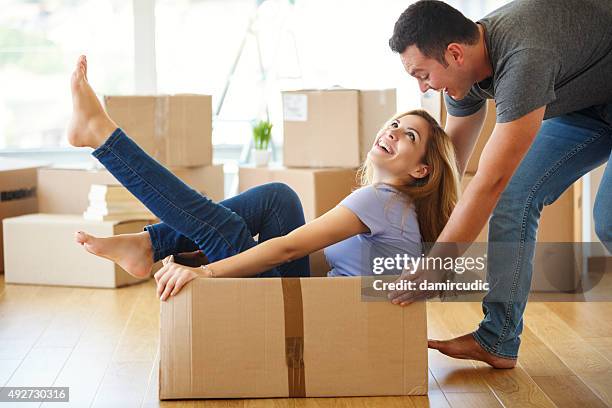 pareja joven divirtiéndose mientras que avanzar en nuevo hogar - casa en exposición fotografías e imágenes de stock