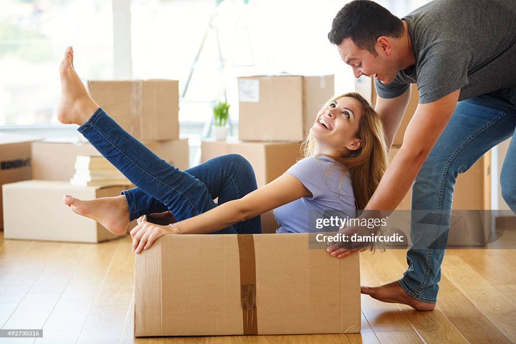 Young couple having fun while they moving into new home