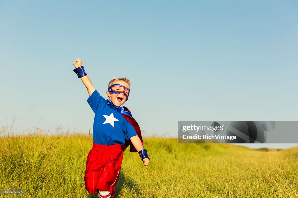 Young Boy dressed as Superhero Raises Arm