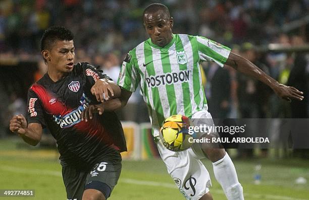 Colombian Atletico Nacional's player Juan David Valencia fights for the ball with Junior's player Johnny Vasquez during the 2014 Colombian Tournament...