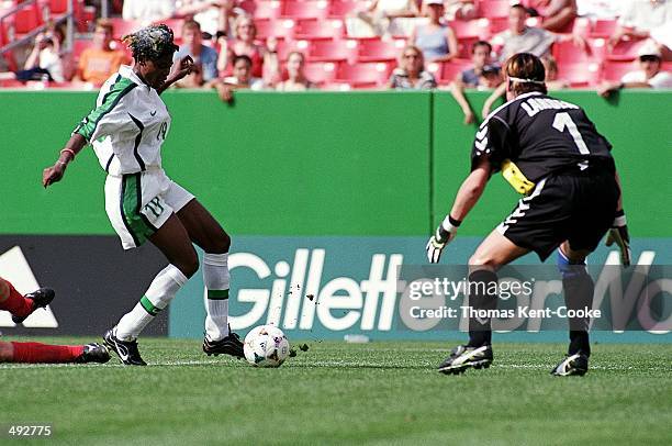 Mercy Akide of Team Nigeria kicks the ball at goalie Dorthe Larsen of Team Denmark during the Womens World Cup Game at the Jack Kent Cooke Stadium in...