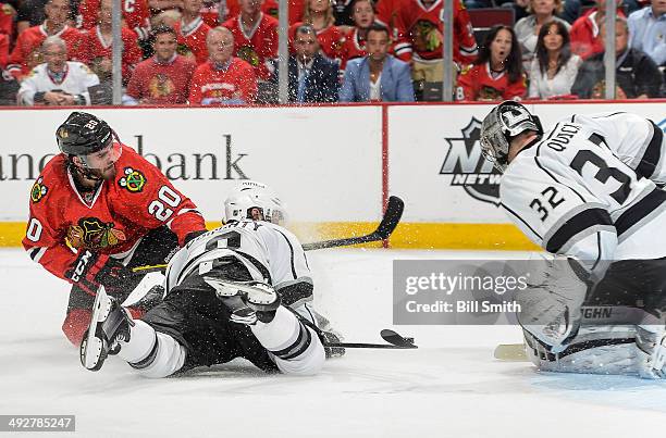 Brandon Saad of the Chicago Blackhawks and Drew Doughty of the Los Angeles Kings get physical in front of goalie Jonathan Quick of the Kings in Game...