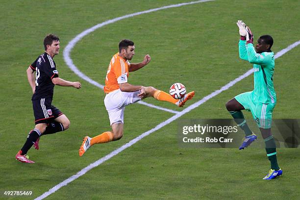 Will Bruin of Houston Dynamo moves the ball past Bobby Boswell and goalie Bill Hamid of D.C. United during the second half at RFK Stadium on May 21,...