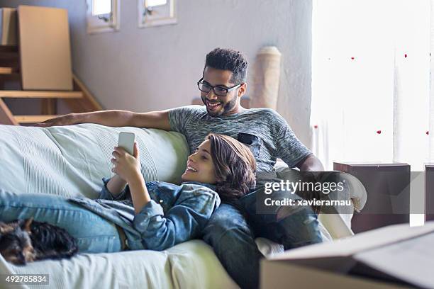 posting on the social media network - young couple on couch stock pictures, royalty-free photos & images