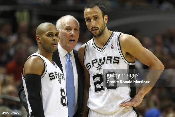 Head coach Gregg Popovich of the San Antonio Spurs talks with Patty Mills and Manu Ginobili in the first half while taking on the Oklahoma City...