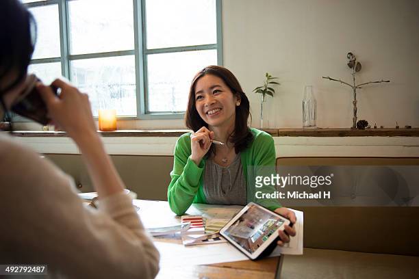 young designer discussing with custmer in cafe - mid adult women stock pictures, royalty-free photos & images