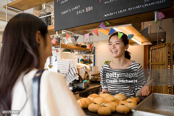 woman buying bread at counter - nur japaner stock-fotos und bilder