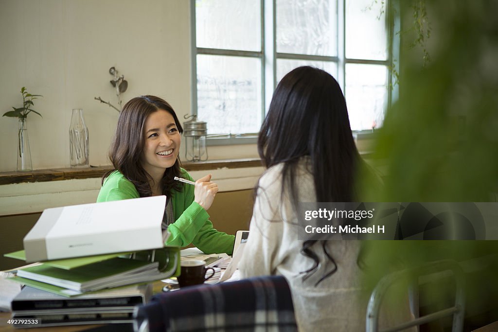 Young designer discussing with custmer in cafe