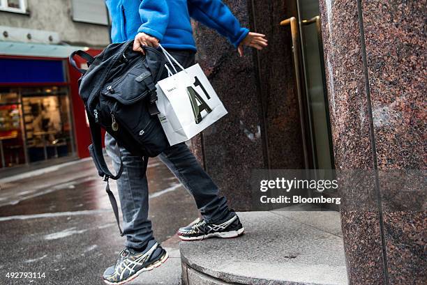 Shopper carrying an A1 bag departs an A1 store, operated by Telekom Austria AG, in Vienna, Austria, on Wednesday, Oct. 14, 2015. Telekom Austria is...