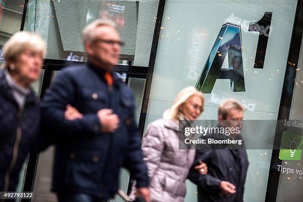 Pedestrian pass by an A1 store, operated by Telekom Austria AG, in Vienna, Austria, on Wednesday, Oct. 14, 2015. Telekom Austria is weighed on by...