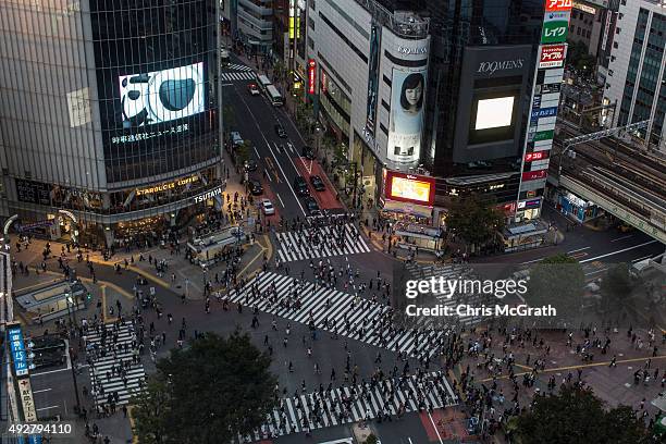 Pedestrians cross the road at Japan's famous Shibuya crossing on October 15, 2015 in Tokyo, Japan.