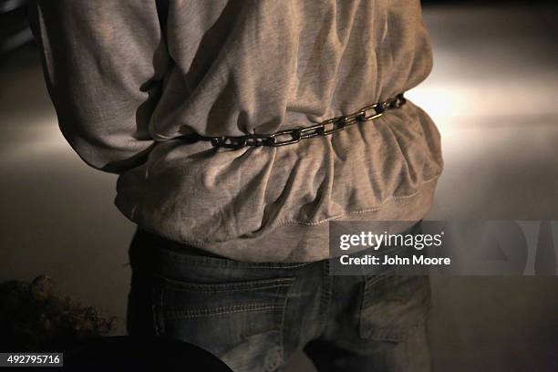 Shackled undocumented immigrant moves towards an Immigration and Customs Enforcement , charter jet early on October 15, 2015 in Mesa, Arizona. The...