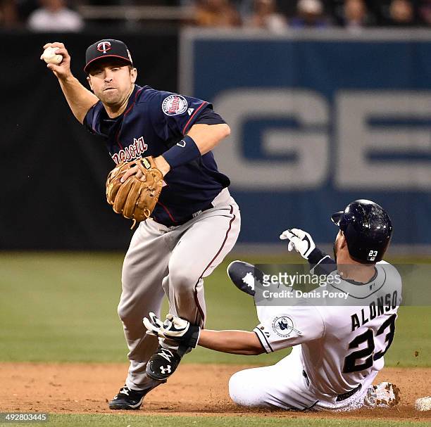 Yonder Alonso of the San Diego Padres slides into Brian Dozier of the Minnesota Twins after being forced out during the sixth inning of a baseball...