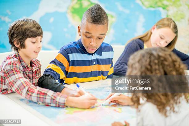 children drawing on a map in class - geography classroom stock pictures, royalty-free photos & images