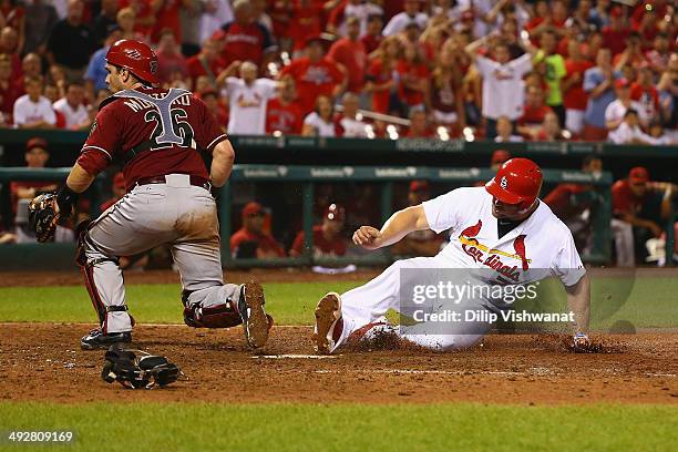 Matt Holliday of the St. Louis Cardinals scores the game-winning run on an errant throw to Miguel Montero of the Arizona Diamondbacks in the twelfth...